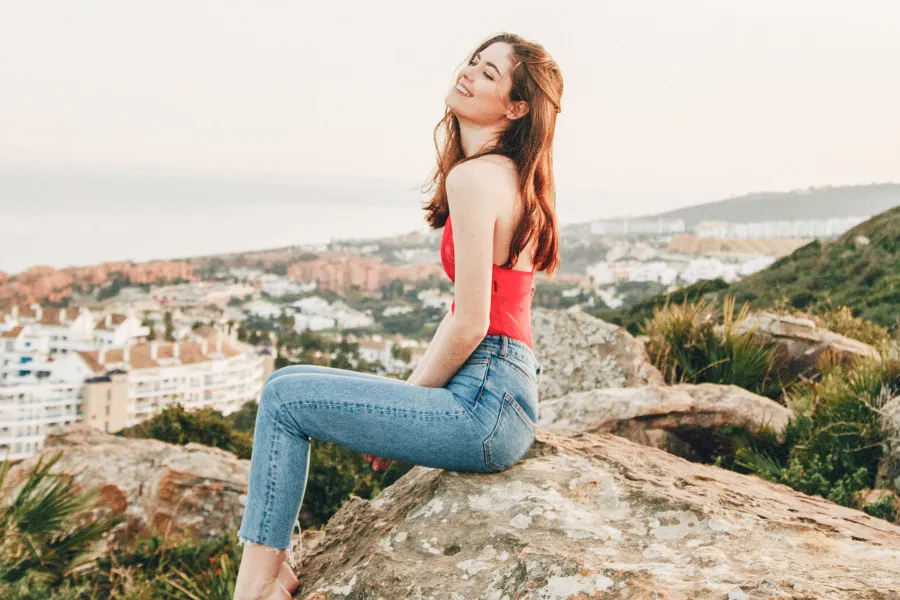 美しい背景を背に達成感あふれる笑顔の女性