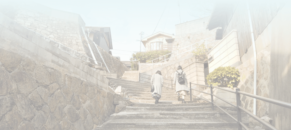 背景画像：女性2人が階段を登っています